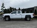 A white 2018 GMC Sierra 1500 pickup truck with a double cab and a ladder rack on the bed