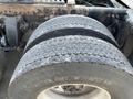 Close-up of the dual rear tires of a 2022 Freightliner Cascadia displaying significant tread wear and damage