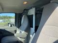 Interior of a 2012 GMC Savana showing two front seats and a partition separating the cargo area from the cab