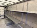 Interior view of a 2012 Ford Econoline showing metal shelving and storage compartments along the walls
