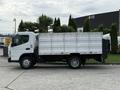 A 2014 Mitsubishi Fuso FE truck with a flatbed and high sidewalls is parked with its profile visible