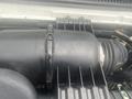 An air intake component of a 2004 Ford Econoline showing a black plastic housing and attached tubing