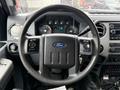 Steering wheel of a 2016 Ford F-350 SD with control buttons and dashboard display visible behind it