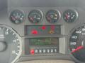 Dashboard of a 2009 Ford F-550 displaying gauges and warning lights with readings for speed, fuel level, and trip information