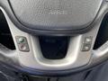 Close-up of the steering wheel controls of a 2015 Kia Sorento featuring buttons for cruise control and other settings