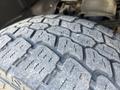 Close-up of the tread on a tire from a 2011 RAM 1500 showing a worn pattern with deep grooves designed for traction and stability on various surfaces.