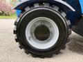 Close-up of the wheel of a 2020 Genie GTH-5519 featuring a rugged tire design and a silver rim with visible bolts and a smooth central hub