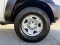 A close-up of a 2015 Toyota Tacoma tire showing a silver wheel with five spokes and a rugged all-terrain tire mounted on it