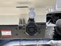 A close-up of a black control valve attached to a silver tank on a vehicle with a warning label visible nearby