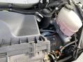 Close-up view of the engine compartment of a 2023 GMC Savana showing various components including the air filter housing and fluid reservoirs