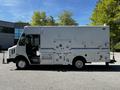 A 2009 Morgan Olson Workhorse delivery truck with a white exterior featuring side storage compartments and a blue stripe along the side
