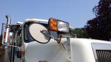 A 2003 International 5600i truck with a prominent side mirror and orange signal light on the cab