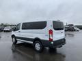 A white 2017 Ford Transit van parked with its rear facing the camera showing a clean design and large windows