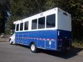 A blue and white 2008 Peterbilt PB340 with multiple windows and a large rear compartment designed for utility or transport