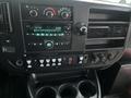 Dashboard of a 2017 Chevrolet Express featuring a radio display climate control knobs and various buttons for vehicle functions and settings