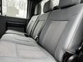 Interior of a 2015 Ford F-550 showing rear seating with gray fabric upholstery and a textured design