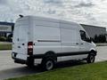 A white 2017 Mercedes-Benz Sprinter van with a high roof and rear cargo doors parked on a street