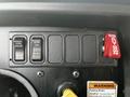 Control panel of a 2013 International 4200 featuring switches for disabling traction control activating parking brake and a shutdown lever