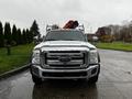 Front view of a silver 2014 Ford F-550 with a black grille and towing equipment mounted on the bed