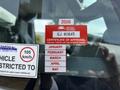A close-up of a red and white vehicle certification sticker with text indicating approval status and months of the year listed