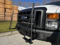 A 2008 Ford F-450 SD in the foreground with a black grille and two vertical support rods attached to the front bumper