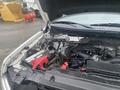 The image shows the open hood of a 2013 Ford F-150 revealing the engine compartment with visible components including the battery and various engine parts