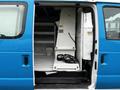 A 2009 Ford Econoline van with its sliding side door open, revealing a spacious interior fitted with shelves and equipment including a white vertical storage unit and some cables