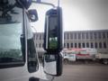 A 2012 International DuraStar 4300 truck with a large side mirror reflecting its surroundings