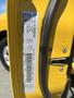 A yellow 2015 RAM 1500 with a visible door sticker displaying vehicle information and specifications