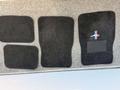 A set of black floor mats designed for a 2003 Ford Mustang including a mat with a Mustang logo and two front and two rear mats laid out flat