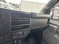 Interior dashboard of a 2022 GMC Savana featuring air vents control knobs and storage compartment