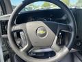 Steering wheel of a 2012 Chevrolet Express featuring a central logo and control buttons on the side