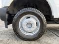A close-up of a 2018 Ford F-350 tire showcasing an off-road tread pattern mounted on a silver steel wheel
