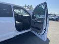 A white 2017 Ford F-150 with its driver's side door open showing the interior and front seat area