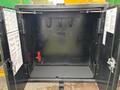 An open black storage compartment with metal hooks and wiring visible inside on a 2015 Freightliner M2 106