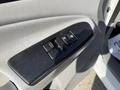 Close-up of the driver's side door panel in a 2015 Toyota Tacoma featuring power window controls and a door lock button