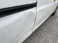 A 2014 GMC Savana with a noticeable dent on the driver's side door