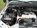The engine compartment of a 2001 Ford F-350 showcasing the engine components battery and various hoses and pipes