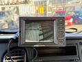A monitor displaying a camera view of the ground with shadows and lines visible connected to a Freightliner M2 106 truck dashboard