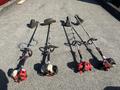 Four Shindaiwa gas powered weed eaters lined up with curved shafts and different attachments on each one including a cutting head and a shoulder strap