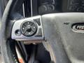 A close-up of the steering wheel controls of a 2022 Freightliner Cascadia featuring a directional pad and buttons for navigation and settings