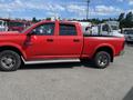A red 2012 RAM 2500 pickup truck with a crew cab and off-road tires parked in a lot