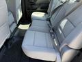 Rear seating area of a 2016 GMC Sierra 1500 with grey cloth upholstery and seatbelts