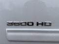 Close-up of the chrome "3500 HD" badge on a white Chevrolet Silverado 3500HD with raindrops on the surface