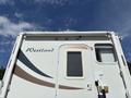 A white and beige 2018 Westland Travelaire RV with a window and a door on the side