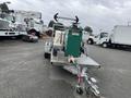 A 2011 Hightliner Aquacide Hot Water Weed Control Dual Flat Deck Trailer featuring a large green tank and various equipment mounted on a metallic frame