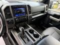 Interior view of a 2019 Ford F-150 showing the dashboard center console with touchscreen and gear shift with cup holders