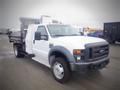 A white 2008 Ford F-550 with a flatbed and equipment mounted in the back parked on a lot