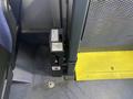 The image shows a black box mounted on the floor of a vehicle next to a yellow step with a textured surface and dark flooring