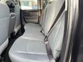 Interior view of the back seat of a 2015 RAM 1500 with gray fabric upholstery and seat belts visible